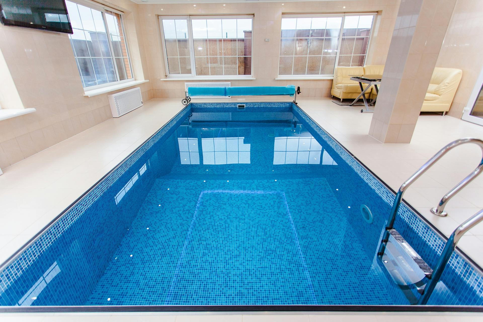 Piscine intérieure avec revêtement en mosaïque et accès par échelle